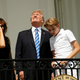 Without his protective glasses on, Trump looks up toward the solar eclipse.